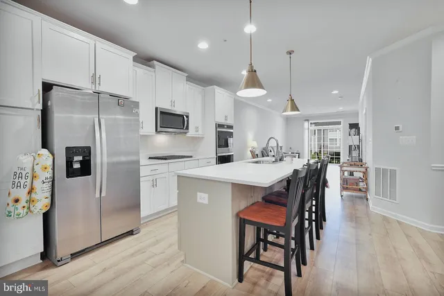 a kitchen with a refrigerator a dining table and chairs