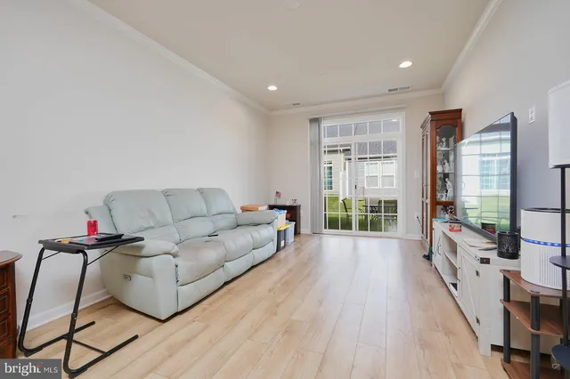 a living room with furniture large window and wooden floor