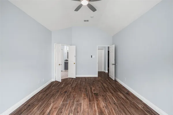 a view of a room with wooden floor a ceiling fan and staircase