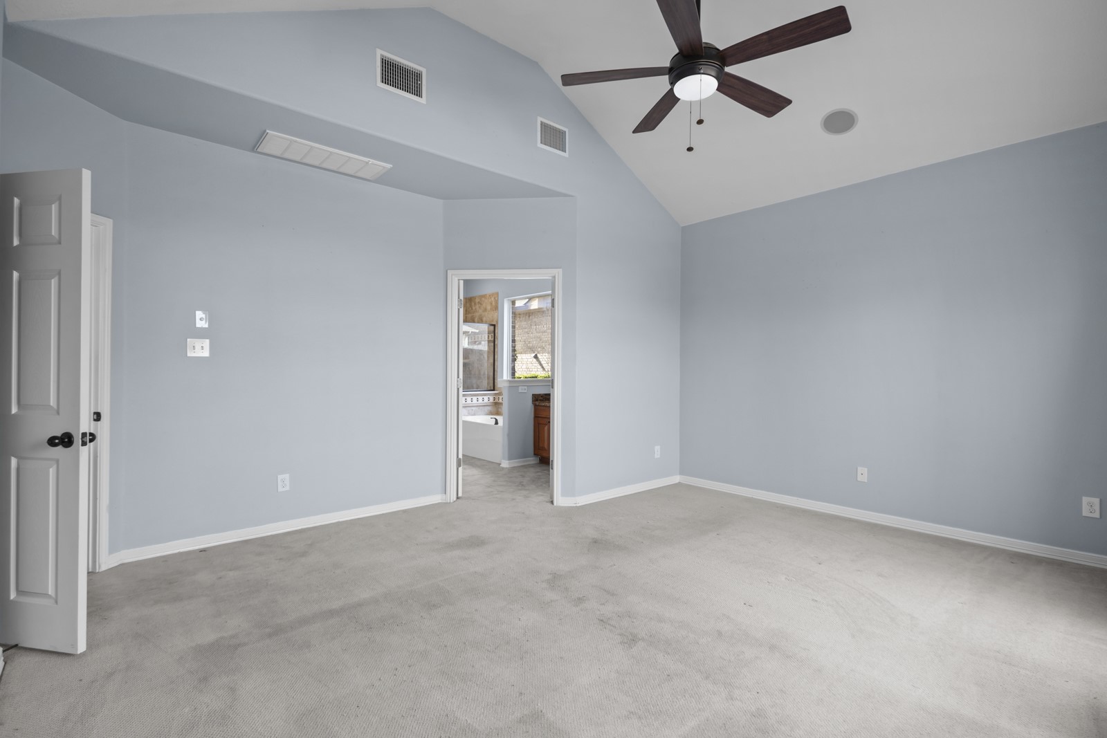 245 Razzmatazz Trail Buda, TX 78610 - Photo 19 of 40 Unfurnished bedroom featuring a high ceiling, light colored carpet, ceiling fan, and connected bathroom