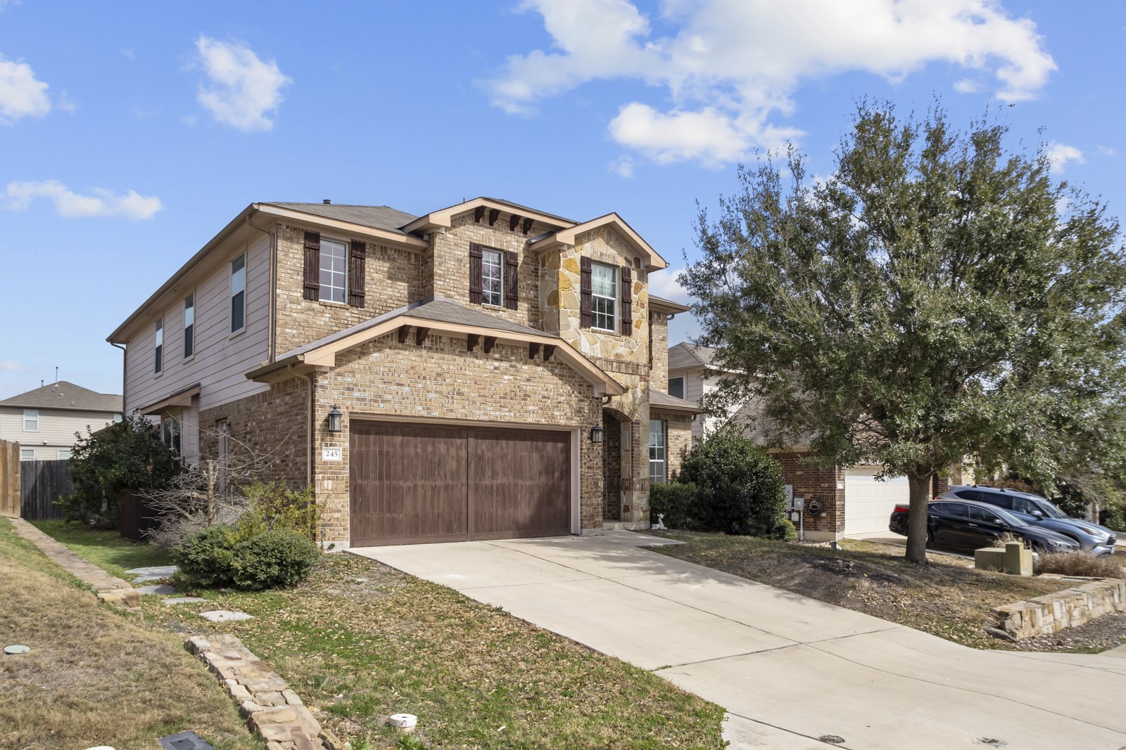 245 Razzmatazz Trail Buda, TX 78610 - Photo 2 of 40 View of front facade featuring brick siding, concrete driveway, stone siding, and a garage