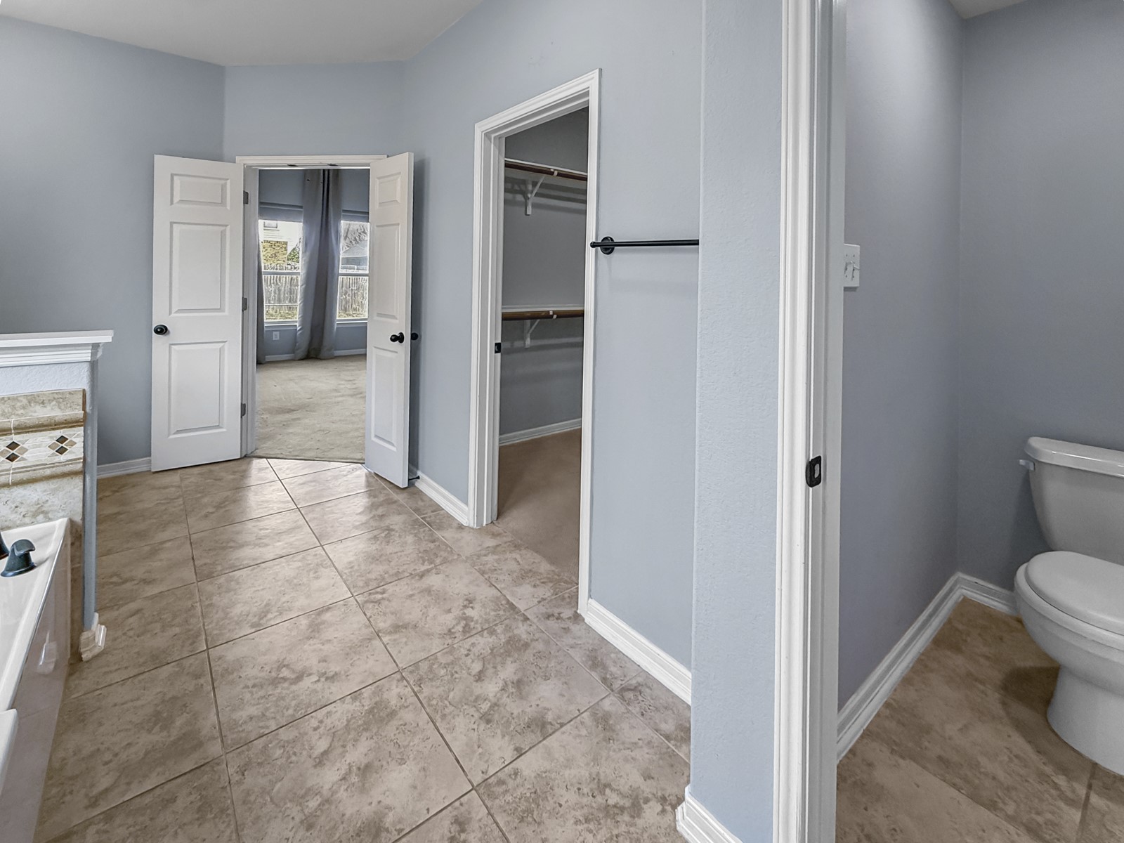 245 Razzmatazz Trail Buda, TX 78610 - Photo 23 of 40 Bathroom featuring light tile patterned flooring, a spacious closet, and a bath