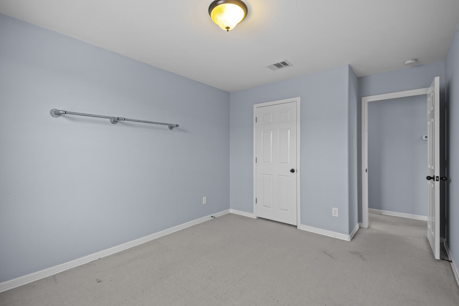 245 Razzmatazz Trail Buda, TX 78610 - Photo 29 of 40 Unfurnished bedroom featuring baseboards and light carpet