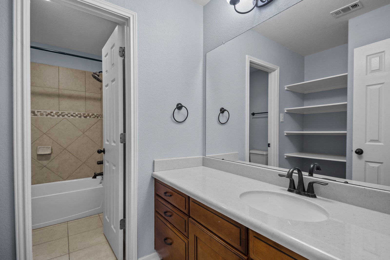 245 Razzmatazz Trail Buda, TX 78610 - Photo 31 of 40 Bathroom with vanity, washtub / shower combination, and light tile patterned flooring