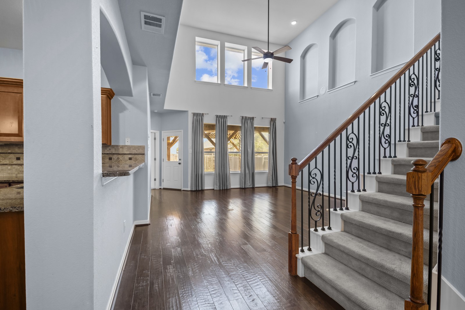 245 Razzmatazz Trail Buda, TX 78610 - Photo 7 of 40 Foyer entrance featuring dark wood-style floors, a ceiling fan, a high ceiling, and recessed lighting