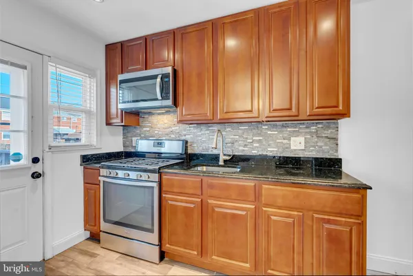 a kitchen with granite countertop cabinets stainless steel appliances and a sink