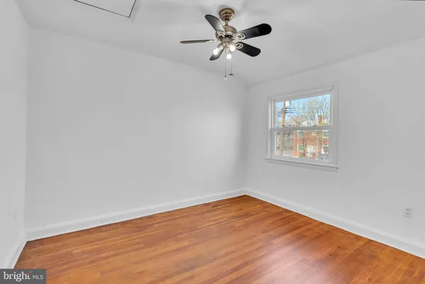 a view of a big room with wooden floor and a ceiling fan