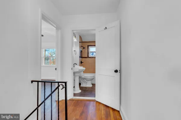 a view of a hallway with wooden floor and furniture