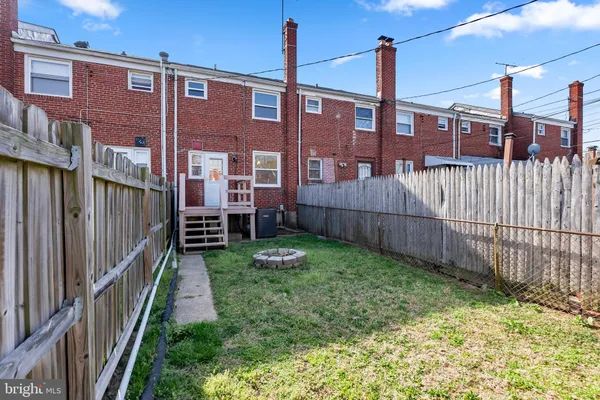 a view of a house with a yard and wooden fence