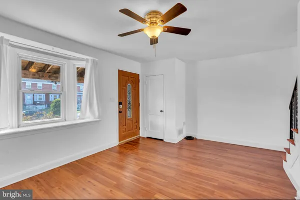 a view of an empty room with window and wooden floor