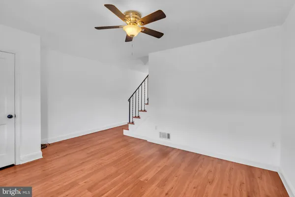 a view of a big room with wooden floor and a ceiling fan
