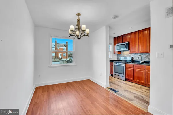 a view of a kitchen with wooden floor and a window