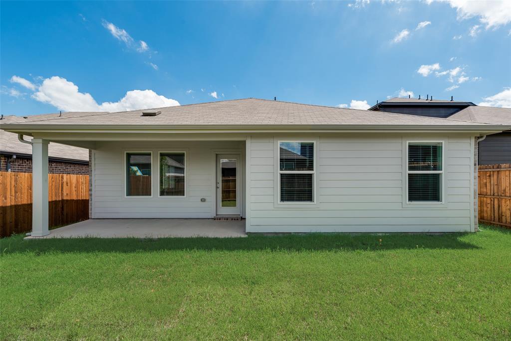 3407 Rendezvous Way Sherman, TX 75090 - Photo 17 of 17 Expansive backyard with green lawn, covered patio, white siding, and wood fencing