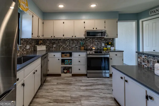 a kitchen with stainless steel appliances granite countertop a stove and cabinets