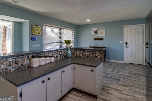 a kitchen with granite countertop a sink and a wooden floor