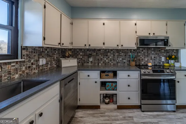 a kitchen with stainless steel appliances granite countertop a sink and a stove