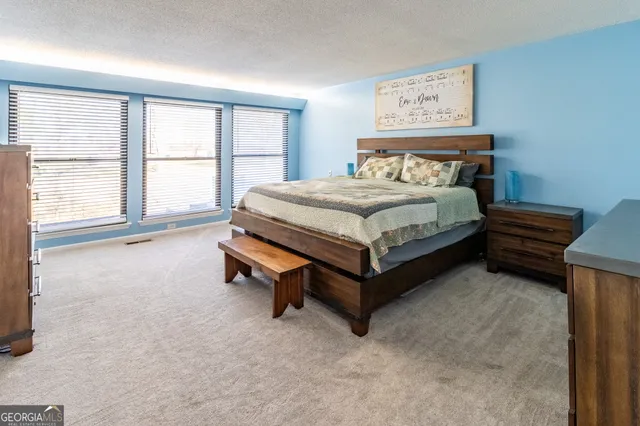 a spacious bedroom with a bed and large windows