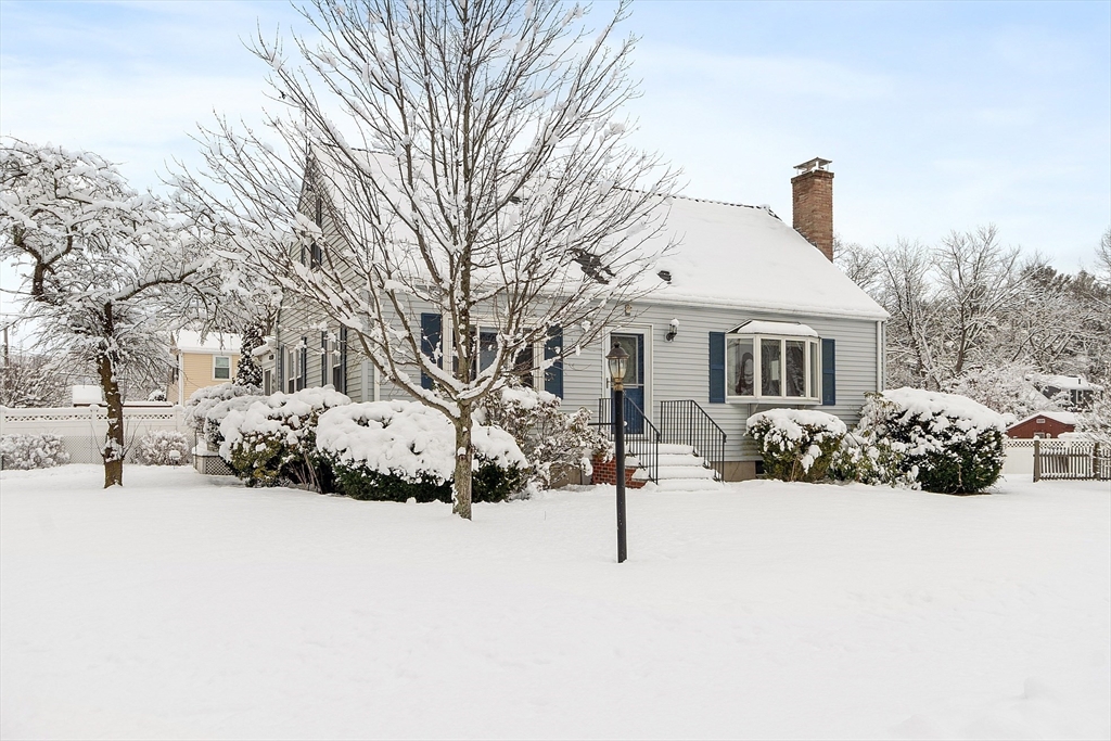 a front view of a house with a yard covered in snow