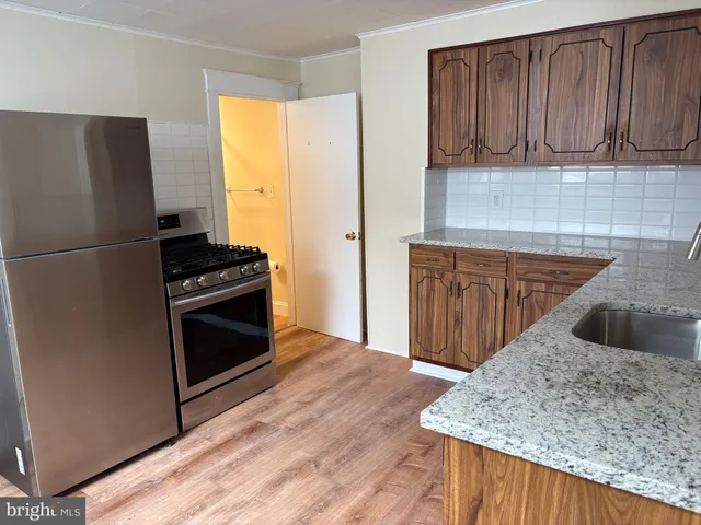 a kitchen with granite countertop a refrigerator and a sink