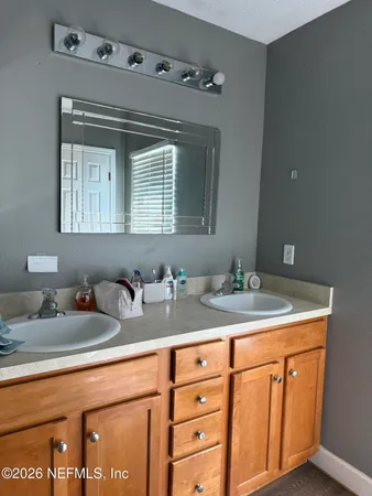 a bathroom with a granite countertop sink and a mirror