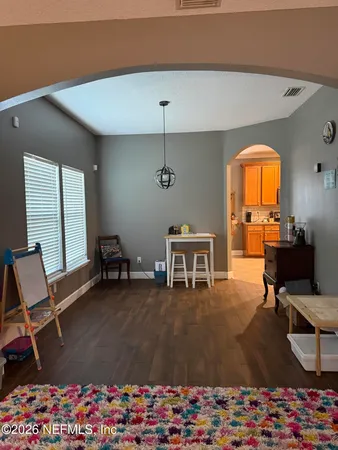 a living room with furniture a piano and a large window