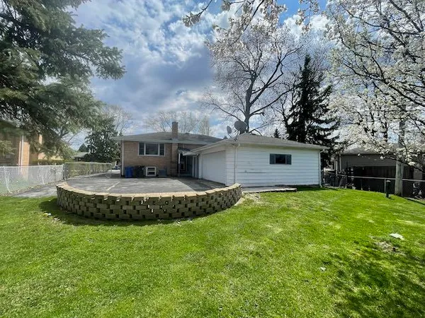 a view of a house with a yard and a large tree