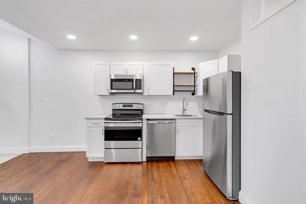 a kitchen with stainless steel appliances a refrigerator and a stove top oven