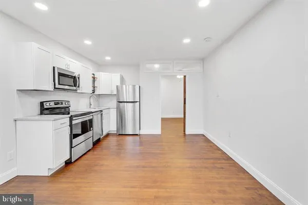 a kitchen with stainless steel appliances a refrigerator and a stove top oven