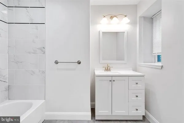 a bathroom with a sink a mirror and a bathtub