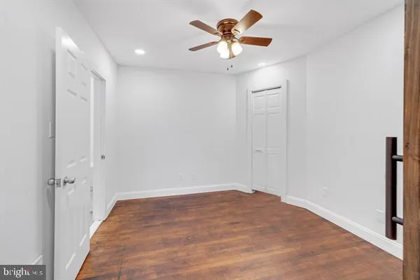 a view of a big room with wooden floor and a ceiling fan