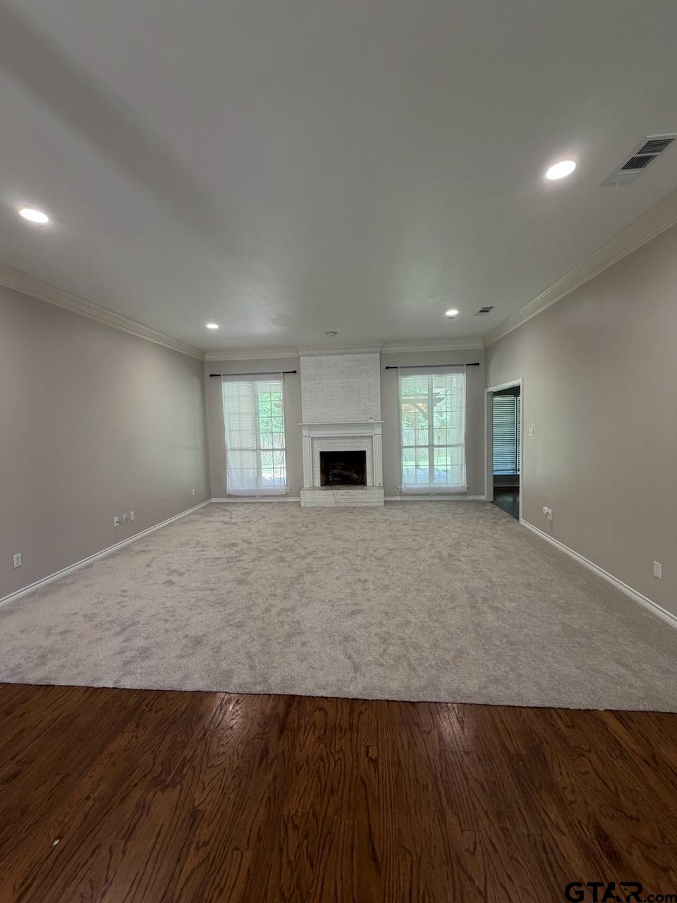 3204 Pebblebrook Circle Tyler, TX 75707 - Photo 6 of 18 an empty room with wooden floor and fireplace