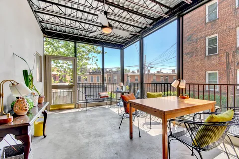 a balcony with furniture and a potted plant