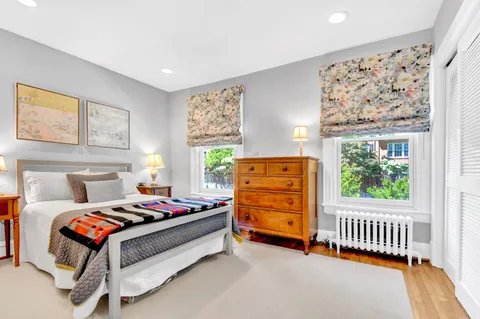 a bedroom with bed and paintings on the wall