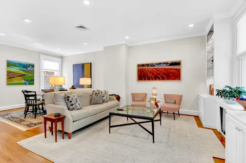 a living room with furniture cabinets and a window
