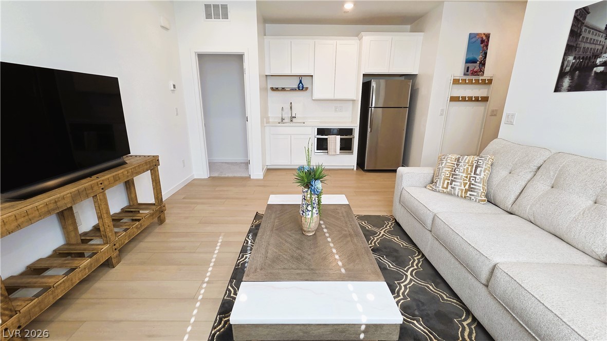 509 Arthur Pointe Street Henderson, NV 89011 - Photo 6 of 12 Blonde hardwood floors extend throughout this open-concept living area with a compact, well-appointed kitchen.