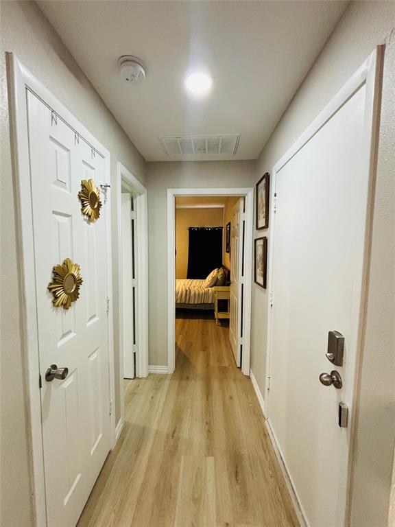 Hallway with wood-finish flooring, recessed lighting, and white paneled doors