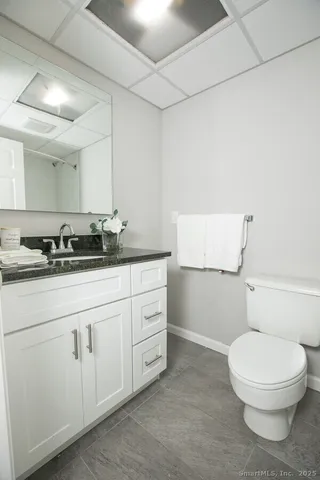 a bathroom with a granite countertop toilet and sink