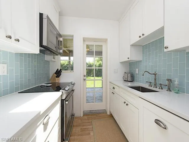 a kitchen with a sink a stove and cabinets