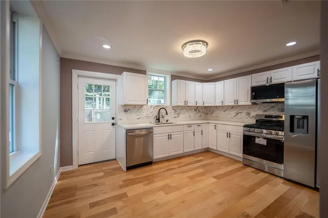 a kitchen with granite countertop a stove top oven sink and cabinets