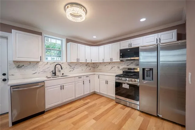 a kitchen with granite countertop stainless steel appliances cabinets a sink and a window