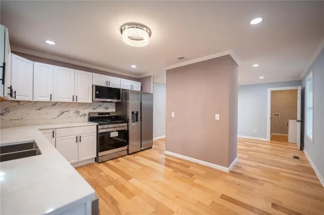 a kitchen with granite countertop a refrigerator stove top oven and sink