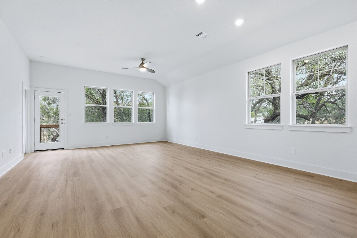 20308 Boggy Ford Road Lago Vista, TX 78645 - Photo 11 of 25 a view of an empty room with wooden floor and a window