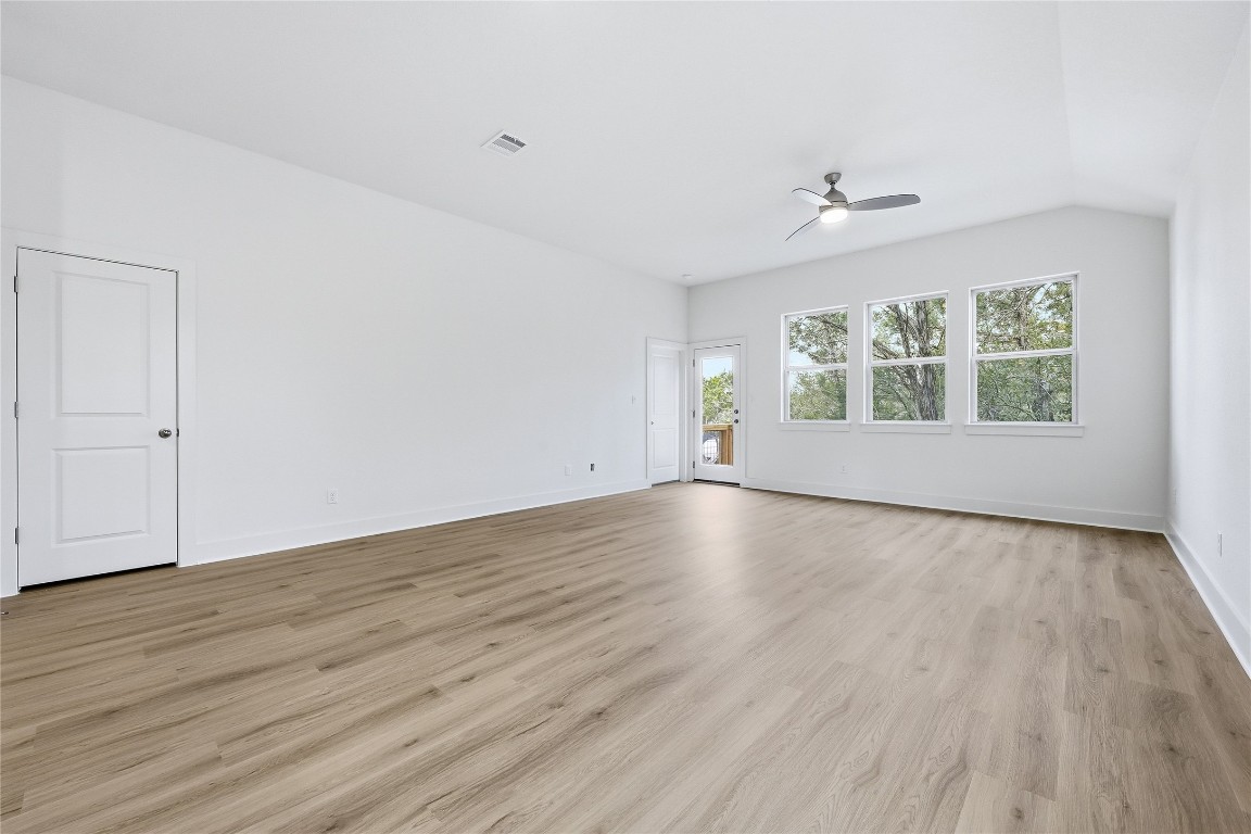 20308 Boggy Ford Road Lago Vista, TX 78645 - Photo 12 of 25 an empty room with wooden floor and windows