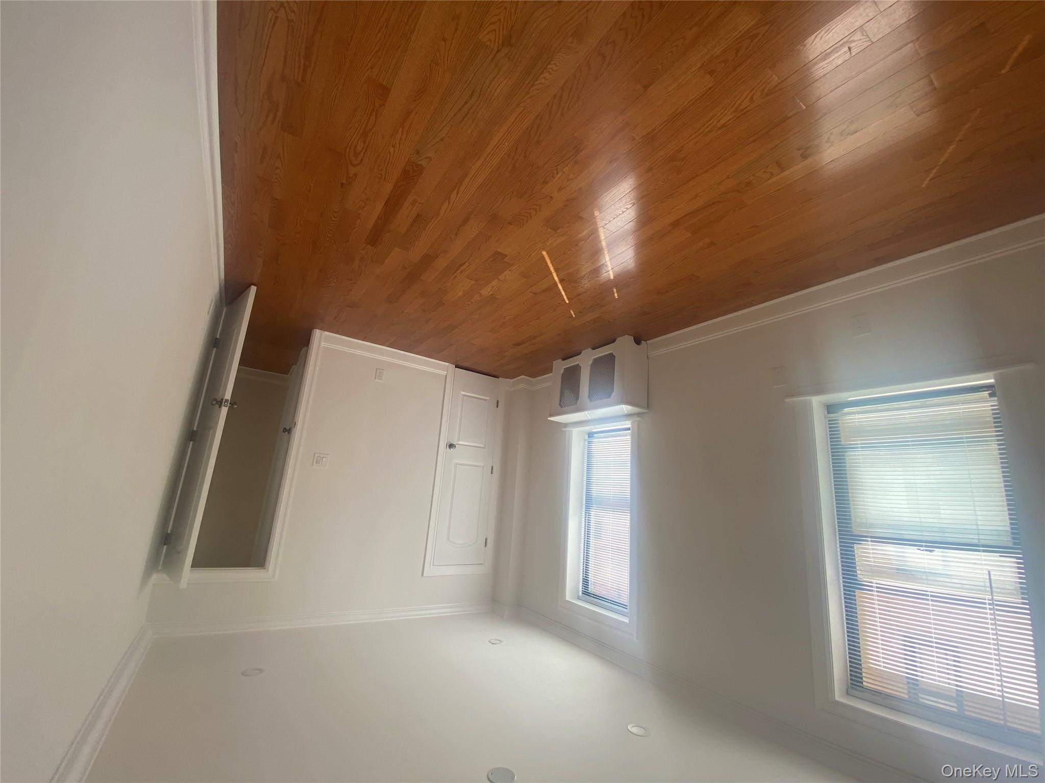 37-21 80th Street, Unit 4M Queens, NY 11372 - Photo 13 of 16 an empty room with wooden floor and windows