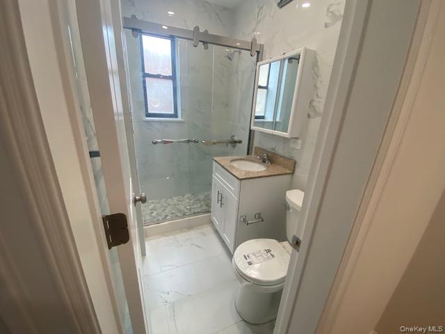 37-21 80th Street, Unit 4M Queens, NY 11372 - Photo 14 of 16 a bathroom with a toilet a sink and a shower