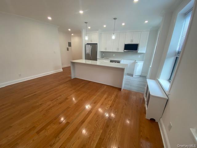 37-21 80th Street, Unit 4M Queens, NY 11372 - Photo 4 of 16 a large kitchen with stainless steel appliances a large counter top