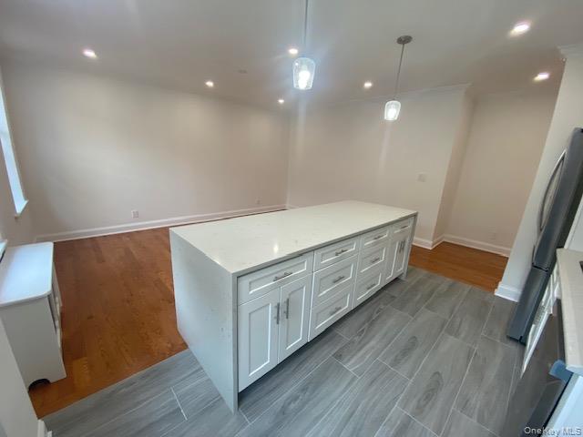 37-21 80th Street, Unit 4M Queens, NY 11372 - Photo 6 of 16 a kitchen with stainless steel appliances a white stove top oven and a sink with wooden floor