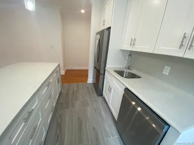 a kitchen with a sink a refrigerator and cabinets