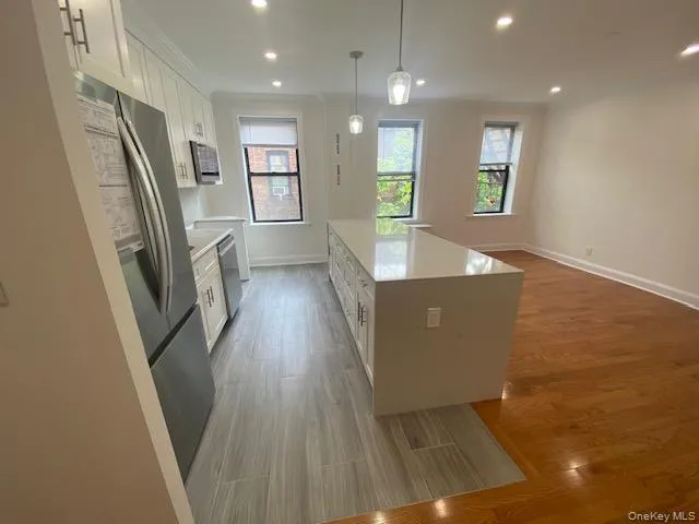 a view of a kitchen with fridge and wooden floor