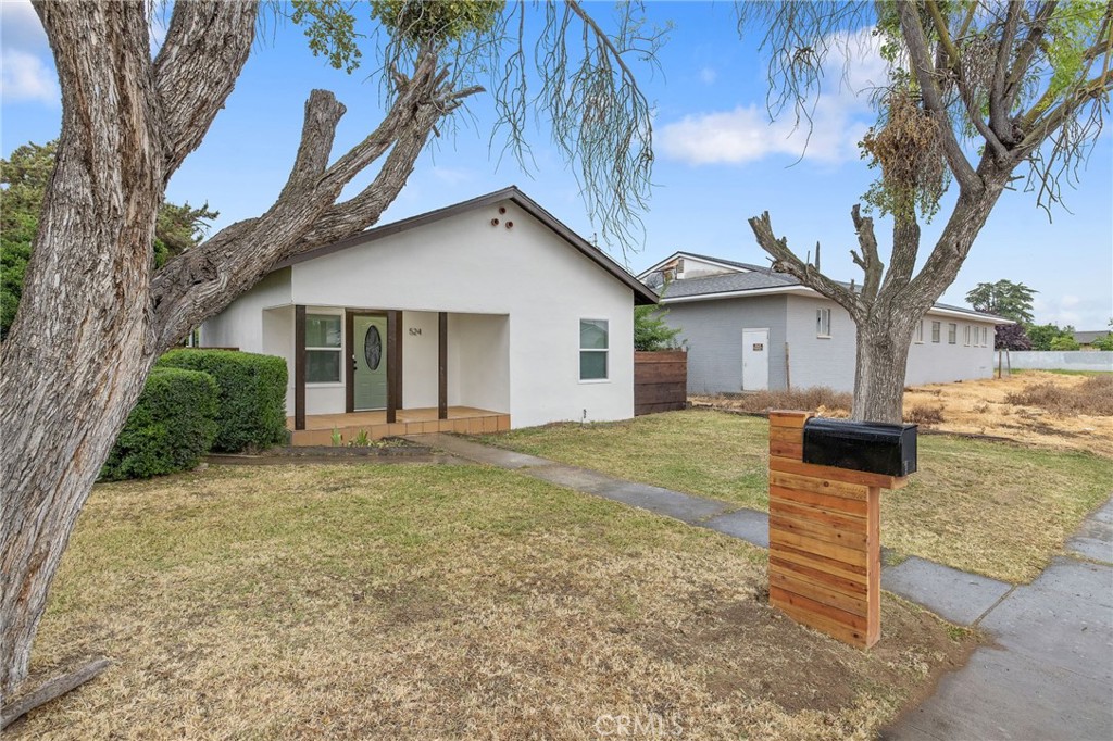 524 South 6th Street Kerman, CA 93630 - Photo 1 of 1 a view of a yard in front of a house with large tree